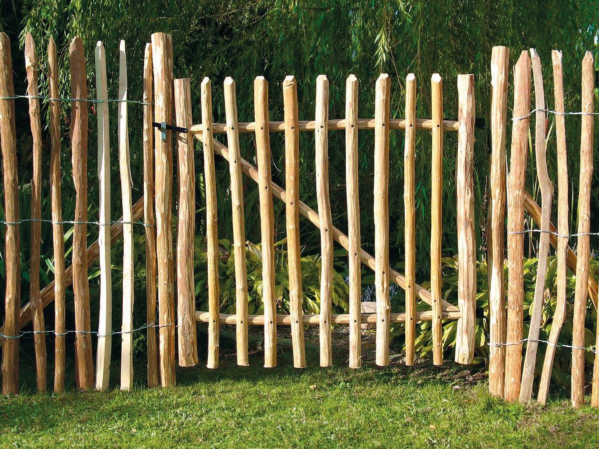 Haselnuss Vorgartenzauntor 100 cm breit, naturbelassen, aus unbehandeltem Holz für einen natürlichen Gartenzaun Haselnuss Vorgartenzauntor, 100 cm breit, naturbelassen; gefertigt aus vertikalen, unbehandelten Haselnussstäben mit unregelmäßiger Form, eingefasst von passendem Zaun, auf Rasenfläche im Garten stehend