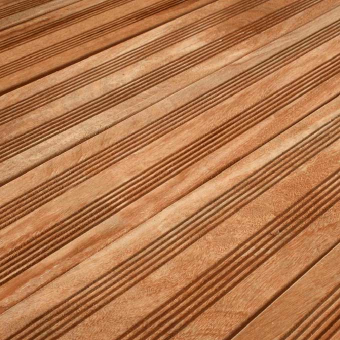 Nahaufnahme einer hellbraunen Holzterrasse mit parallel verlaufenden, gerillten Dielen in diagonaler Perspektive