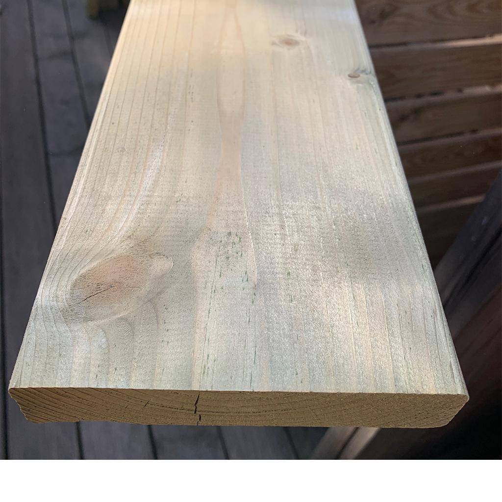 Fichte 28×142×1800 mm, kammergetrocknet, gehobelt und kesseldruckimprägniert; Nahaufnahme eines Bretts mit gerundeten Kanten, sichtbarer Stirnseite, Holzmaserung, Aststelle und leicht grünlicher Imprägnierung